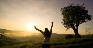 woman open arms at sunrise